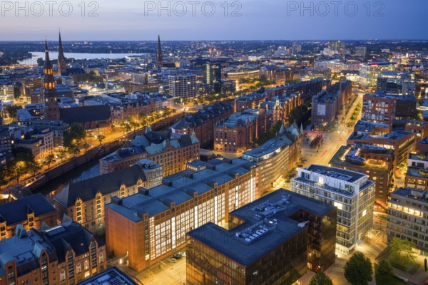 Aerial view of the Speicherstadt Hamburg at blue hour with churches and Alster in the background,