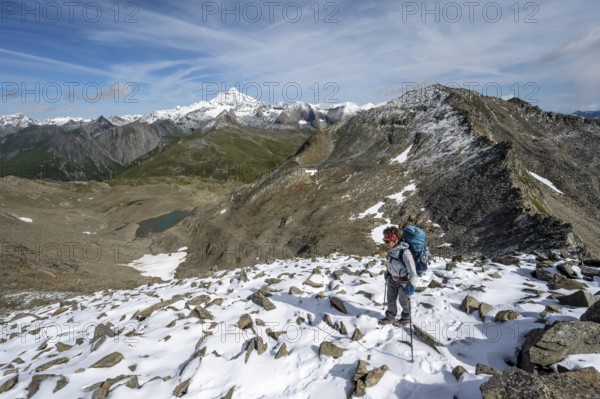 Mountaineer in boulder terrain with fresh snow in summer, ascent to the summit Böses Weibl, view of