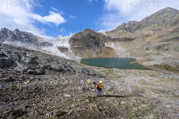 Mountaineer on a hiking trail, mountain landscape with limestone rocks between granite mountains,
