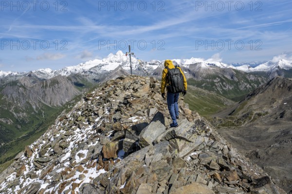 Mountaineers at the summit of Böses Weibl with summit cross and colourful prayer flags, view of