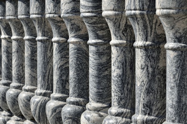 Beautiful gray marble balustrade illuminated by the bright sun. Stone background