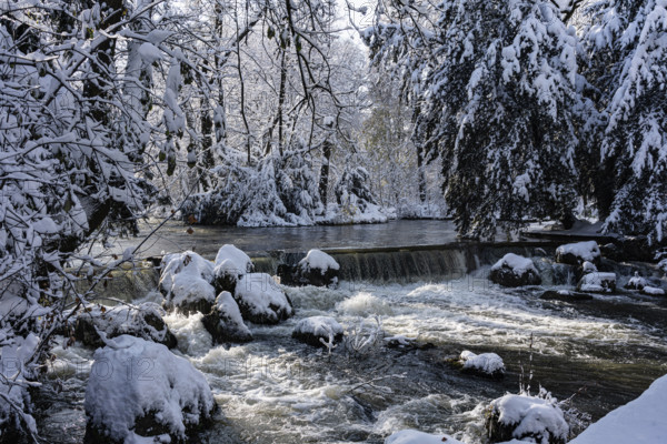 Waterfall at the Eisbach, winter with snow in the southern part of the English Garden, Munich,