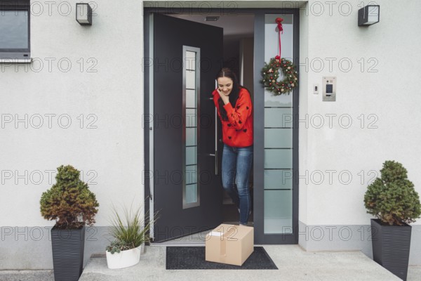 Cheerful young woman excited over a package she just received. Woman getting her christmas gift in
