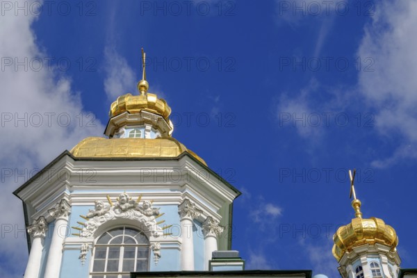 Baroque building with a blue façade and magnificent golden domes against a deep blue sky in St.