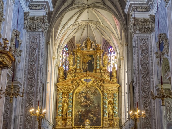 Gold-decorated altar in the Baroque church interior with ornate paintings and decorative details on