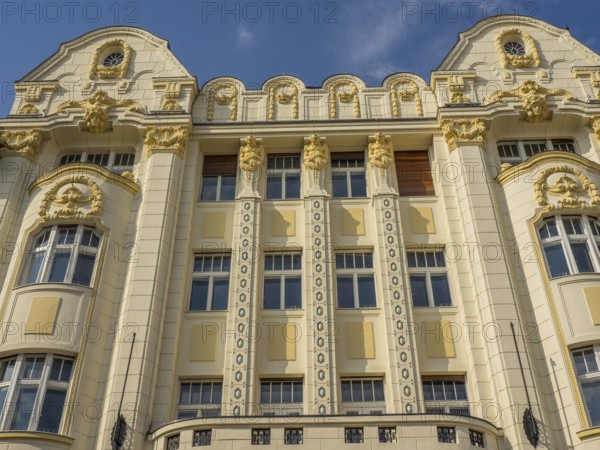Historic building with ornate façade, stucco work and gilded elements under a blue sky, bratislava,