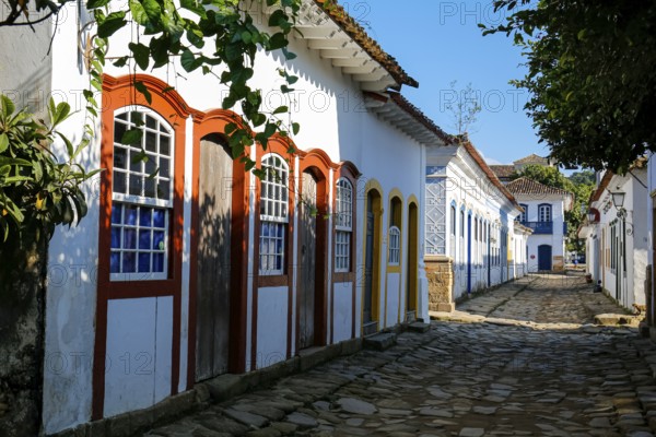 Typical cobblestone street with colorful colonial buildings in the late afternoon sun and shadows