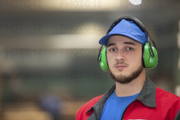 Belarus, Gomil. Wood processing plant. April 25, 2022.Close-up of a male worker wearing soundproof