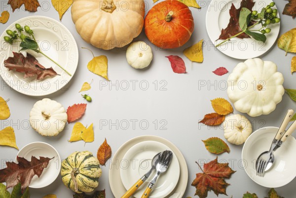 Thanksgiving festive table composition with different colourful pumpkins, autumn leaves, empty