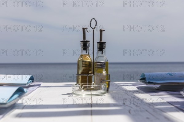Bottle with vinegar and oil on a restaurant table, Perissa, Santorini Island, Cyclades, Greece,