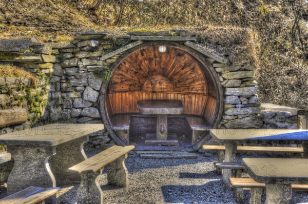 Rustic Restaurant with Tables and Benches Made in Stone and Wood in Circle Shape in a Sunny Day in