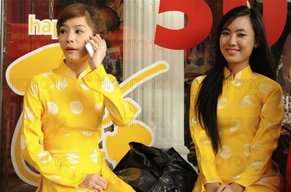 Saigons Beauties: Two woman preparing for the new year celebration. Two young beautifully dressed