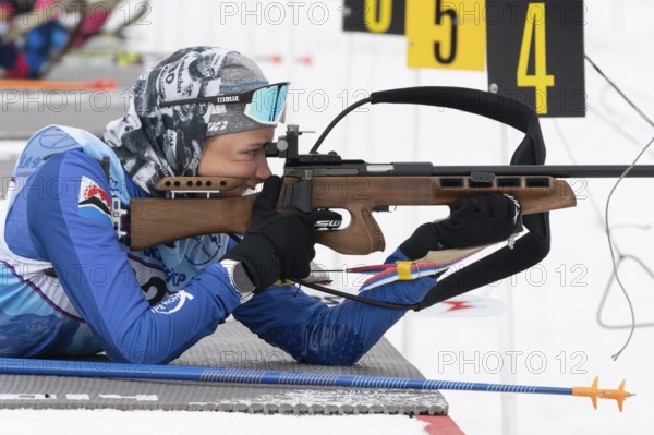 Sportswoman biathlete Arina Soldatova Kamchatka Krai rifle shooting prone position. Biathlete in