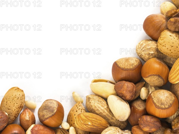 Background of closeup mixed nuts - hazelnuts, almonds, walnuts, pistachios, peanuts, pine nuts