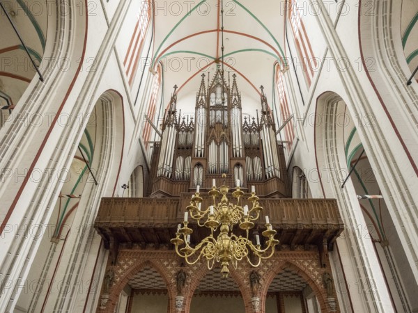 Interior view of a church with a large organ and a chandelier, Gothic architecture, Schwerin,