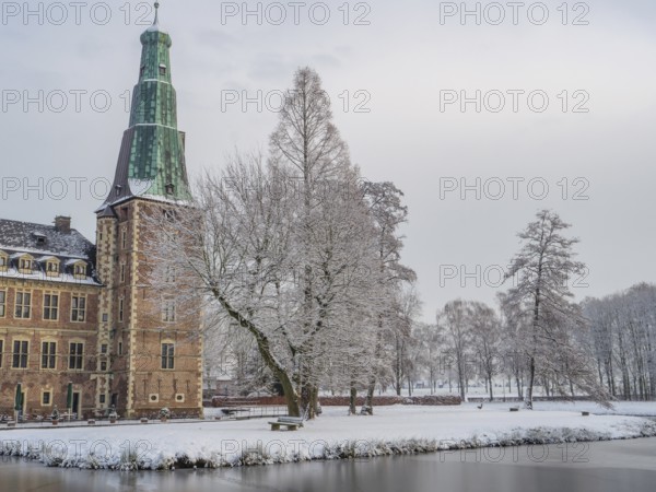 Snow-covered castle and lake in winter with trees and historic architecture, Raesfeld, münsterland,