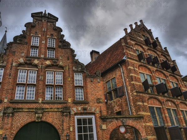 Historic brick houses with ornate facades, dramatic clouds in the sky, zutphen, gelderland,