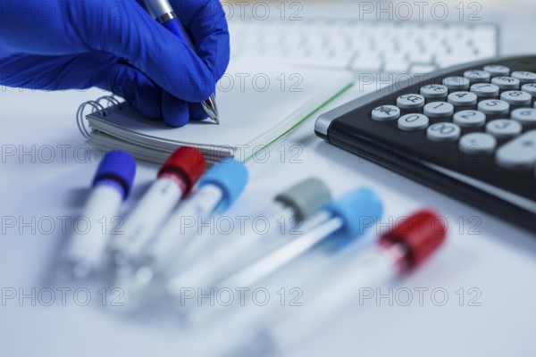 Close up photo of medicine bottles for samples next to computer tablet and computer keyboard in