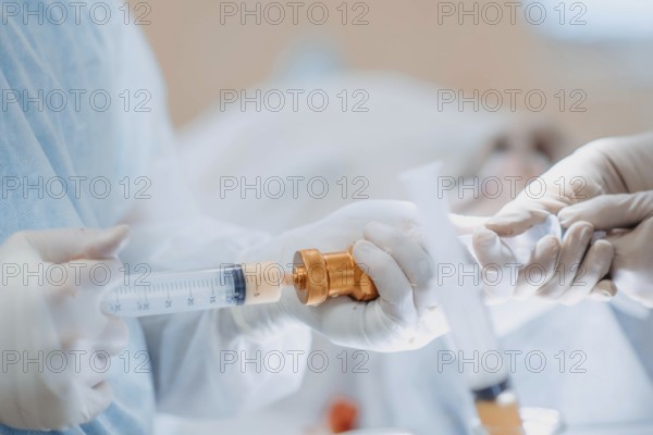 Close-up of a syringe handled by healthcare professionals, showcasing precision in a procedure