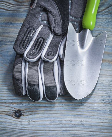 Safety gloves hand shovel on wooden board gardening concept