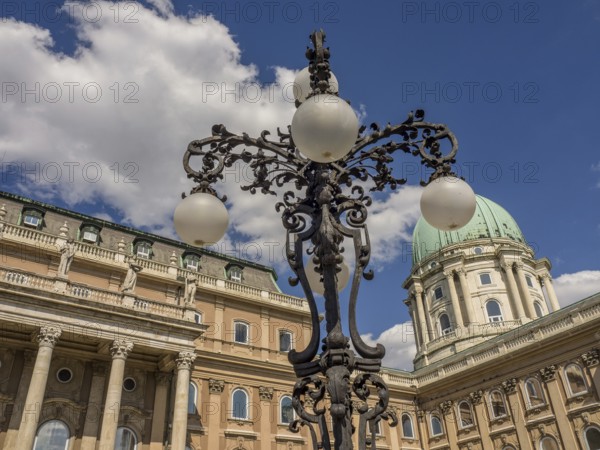 Historic lantern and building with green dome in Budapest under a cloudy sky, budapest, danube,