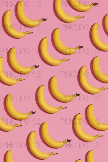 Food design. Pattern composition of a pair of bananas lying next to a pink background. Mock up, top
