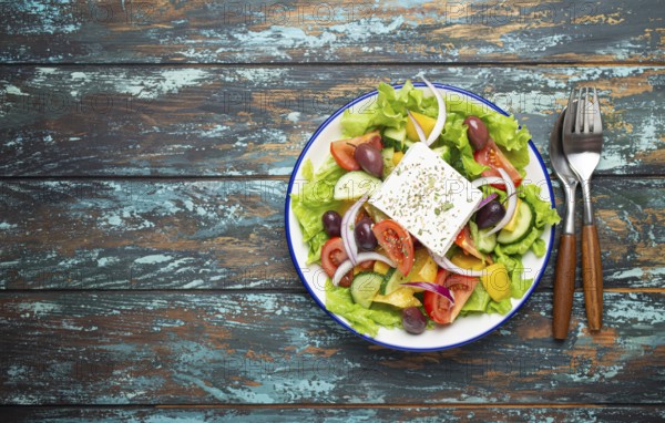 Traditional Greek Salad with Feta Cheese, Tomatoes, Bell Pepper, Cucumbers, Olives, Herbs in white