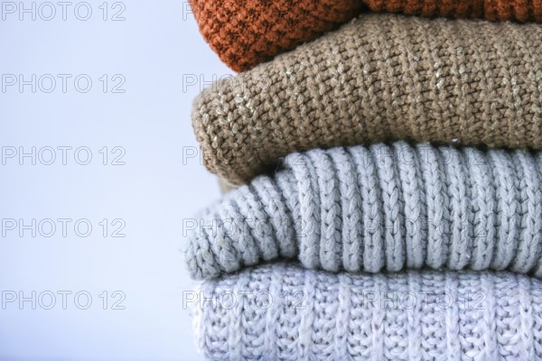 Stack of cozy knitted warm sweater. Sweaters in retro Style. Orange and blue colors. Cozy hygge