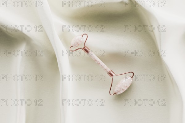 Quartz beauty face roller on white silk 3D rendering