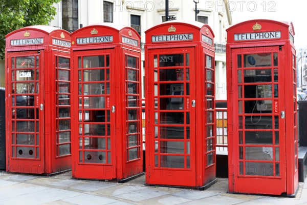 Europe, Several red telephone boxes on a city street, London, London region, England, United
