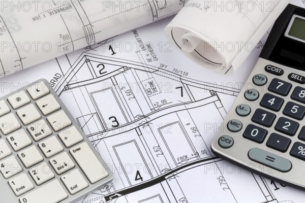 An architect's construction plan with a calculator. Symbolic photo for financing and planning a new