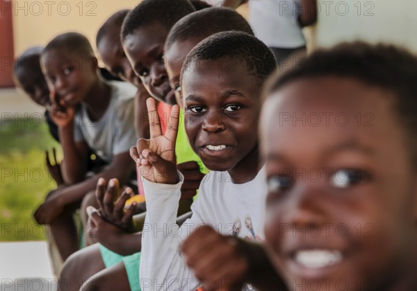 Children making a peace sign with their hands. Snapshot. It was taken during a rubbish collection
