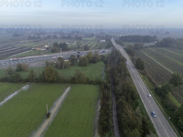 Aerial view of a highway crossing the italian countryside after heavy rain, with flooded fields and