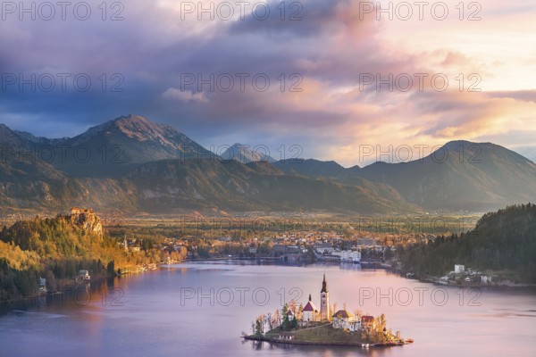 Colorful sunrise over the Bled lake, its surrounding hills, its island and the Karawanks mountains