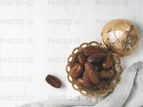 Metal plate of sweet dried dates and linen cloth on gray cement background. Dried dates with copy