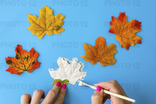 Maple leaf with painted face as decoration for autumn Halloween holiday celebration. Halloween