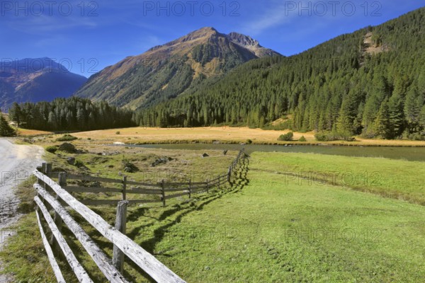 Rural idyll. Headwaters National Park Krimml waterfalls. Farm fields separated from the dirt road