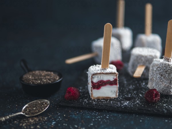 Homemade raw lamington ice cream pops on dark background. Australian sweet dessert lamington with
