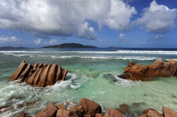 Rocks in the water at Anse Banane, with Felicite Island behind, La Digue Island, Seychelles, Indian