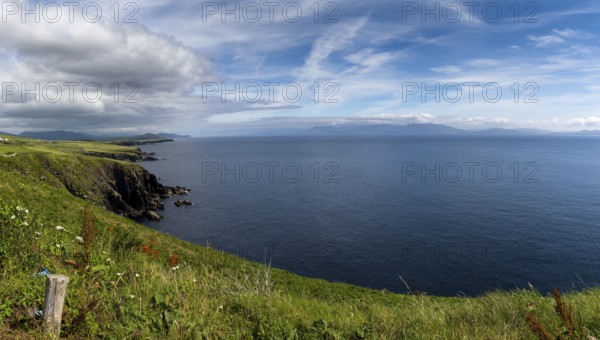 Picturesque coastal landscape with green meadows and rugged cliffs on a beautiful summer day on the