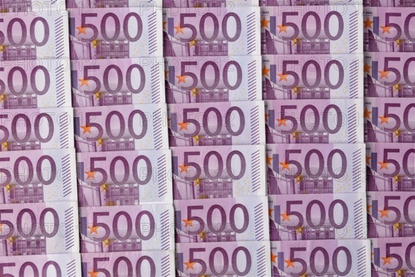 Many five hundred euro banknotes lying next to each other. Symbolic photo for wealth and investment