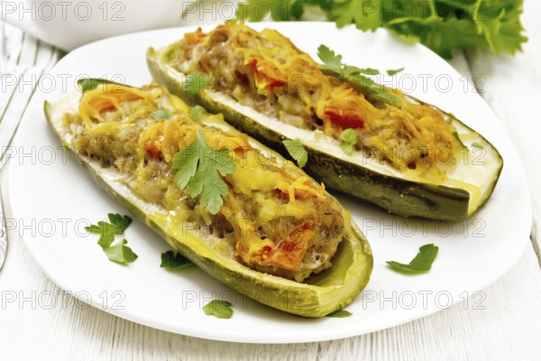 Cucumbers stuffed with minced meat, tomatoes, pepper with cheese and parsley in a plate, cream and