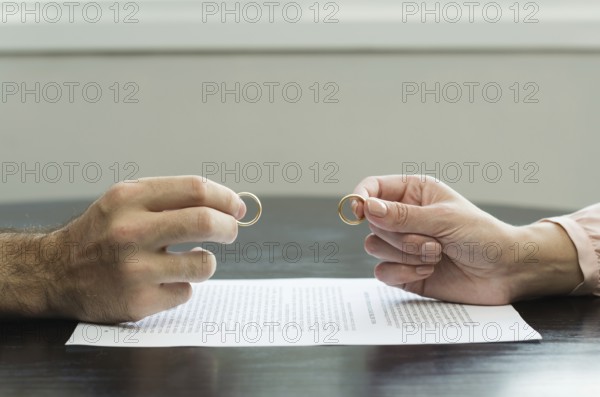 Great concept of divorce, end of relationship, hand of man and woman handing over alliances,