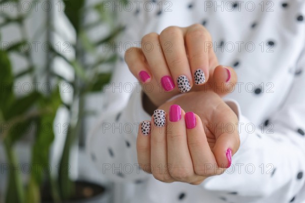 Manicured female hands with stylish pink nails and design. Trendy modern design manicure. Gel nails