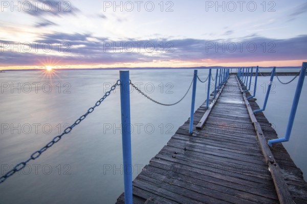 Water landscape, taken from the shore of a calm lake. View over the reflecting water to the horizon