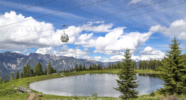 Small lake on the Planai with gondola lift. Smal water reservoir on a mountain by schladming,