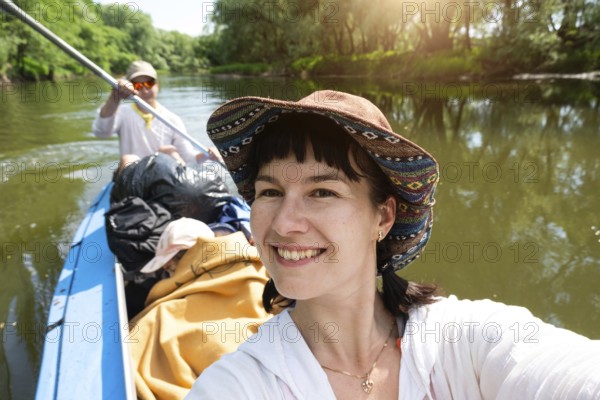 Man and woman couple, baby is sleeping, selfies are happy in family kayak trip rowing boat on the