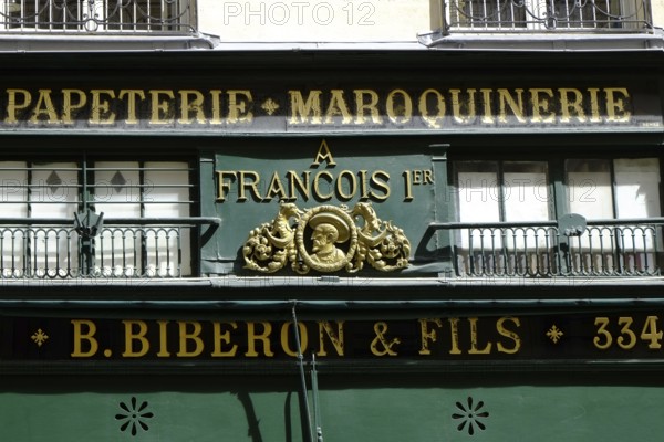 Shop front with golden letters on a green background. Landscape format. Front of a shop with golden