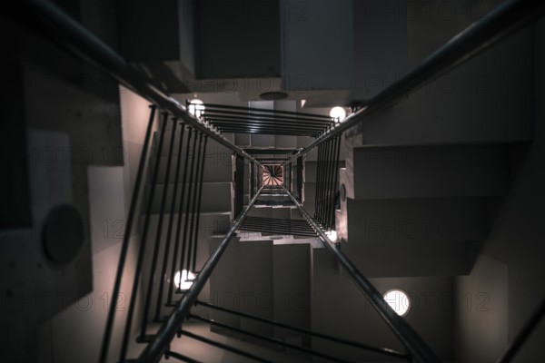 Abstract architectural image with a modern staircase on many levels, viewed from down to up, with