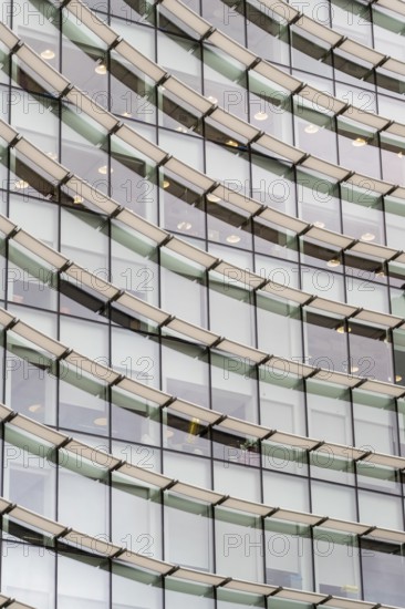 Abstract mosaic of geometric shapes adorns the modern building's facade, doubling as a captivating